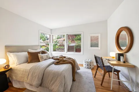 a bedroom with a bed a mirror and a window