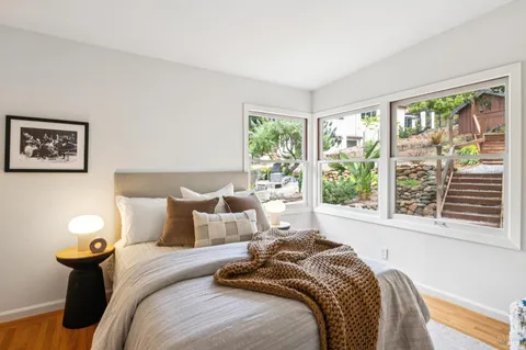 a bed sitting in a bedroom next to a window