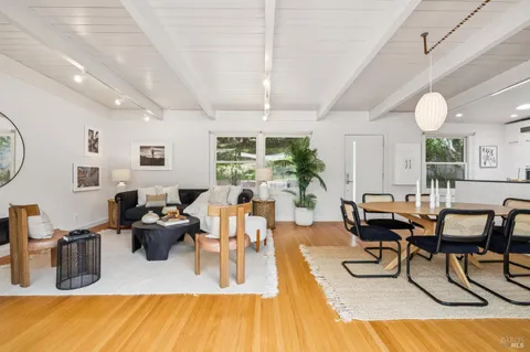 a living room with furniture dining table and a large window