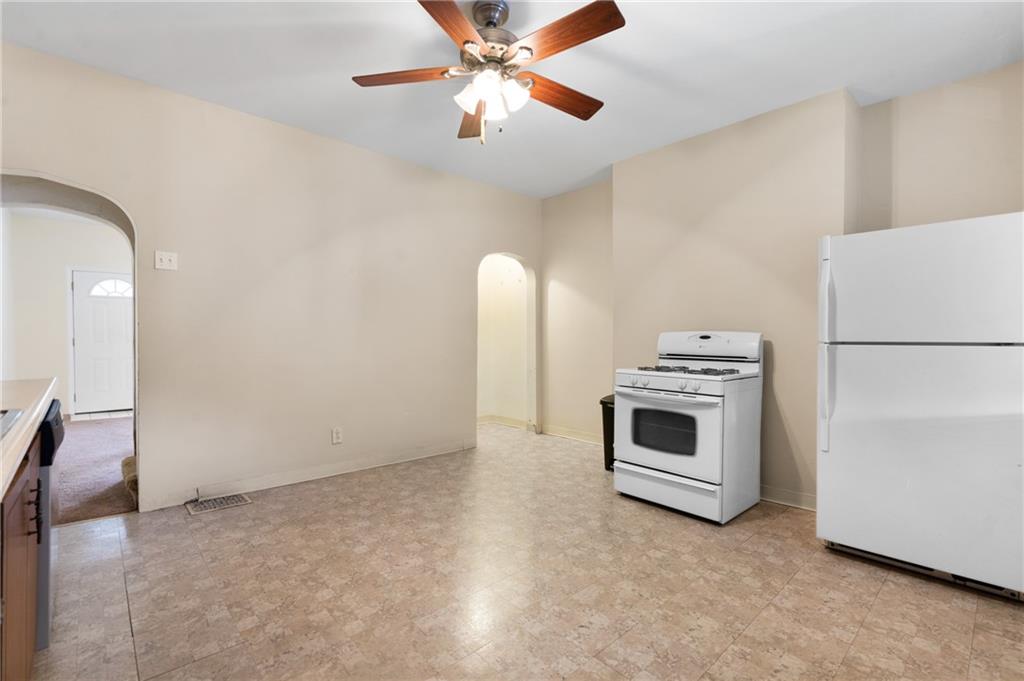 316 Stanton Pittsburgh, PA 15209 - Photo 13 of 32 a view of a livingroom with a fireplace a ceiling fan and a stove top oven