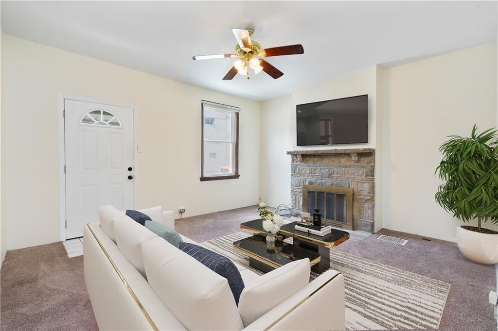 316 Stanton Pittsburgh, PA 15209 - Photo 4 of 32 a living room with furniture a fireplace and a flat screen tv