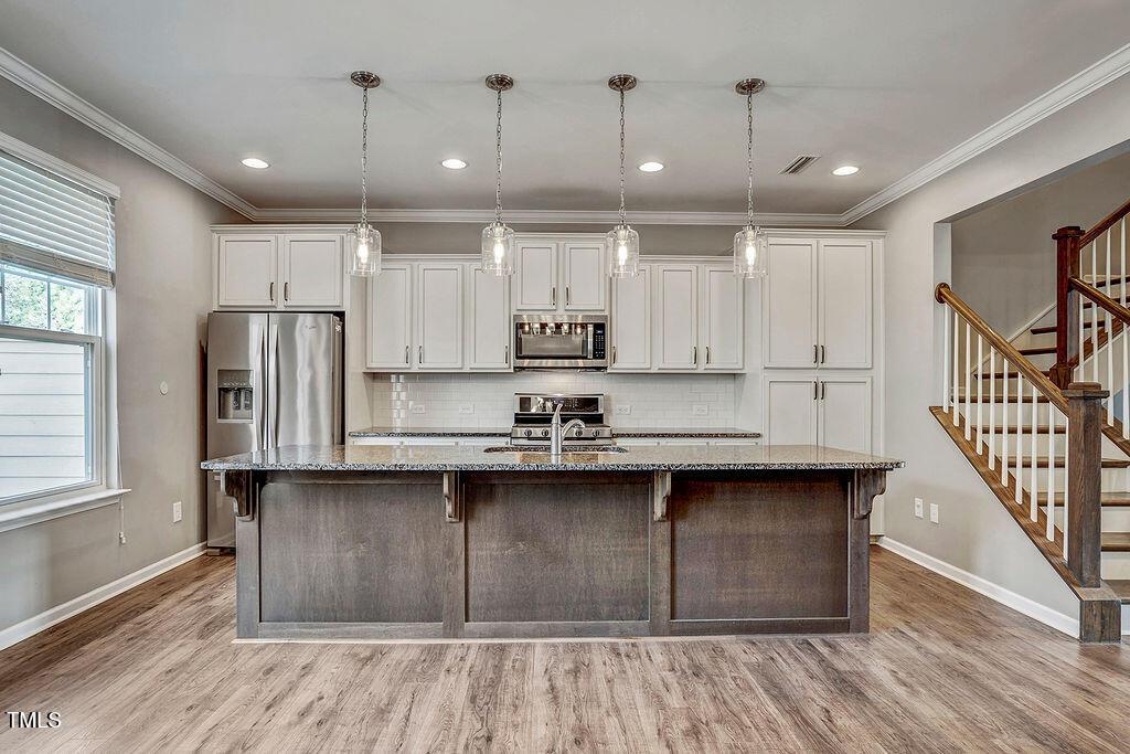529 Metro Station Apex, NC 27502 - Photo 14 of 28 a kitchen with stainless steel appliances granite countertop a sink and cabinets