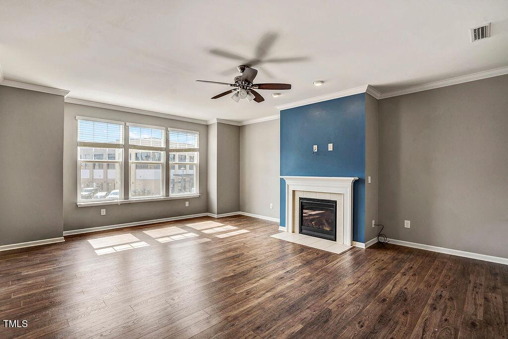 529 Metro Station Apex, NC 27502 - Photo 7 of 28 an empty room with windows fireplace and wooden floor