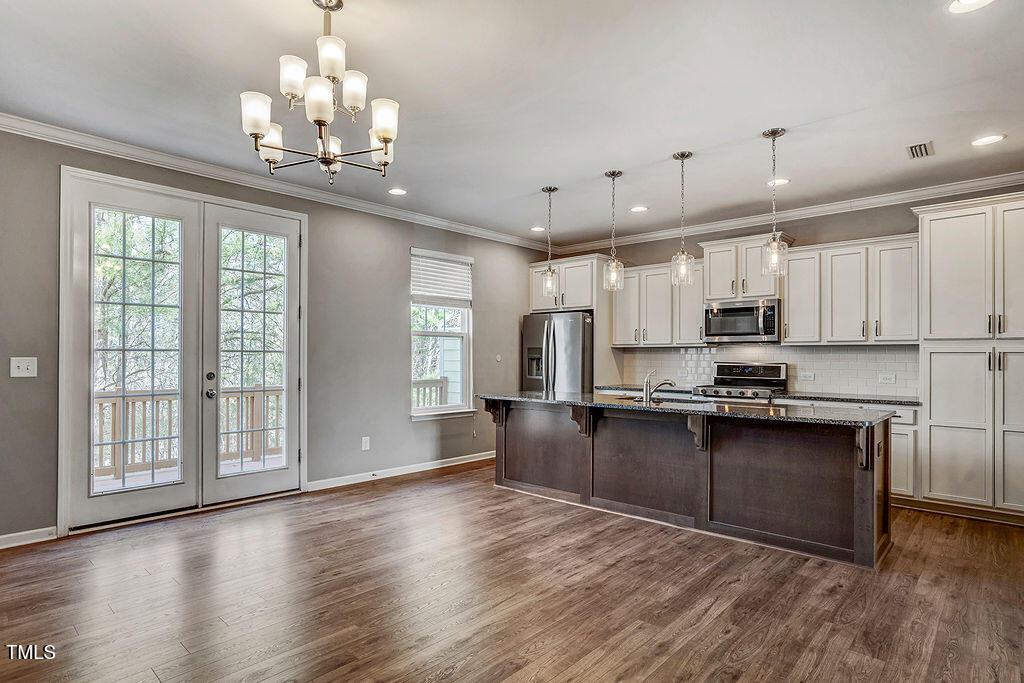 529 Metro Station Apex, NC 27502 - Photo 10 of 28 a large kitchen with stainless steel appliances granite countertop a oven and a view of living room