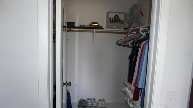 a view of walk in closet with clothes and shoes