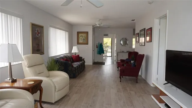 a living room with furniture a ceiling fan and a window