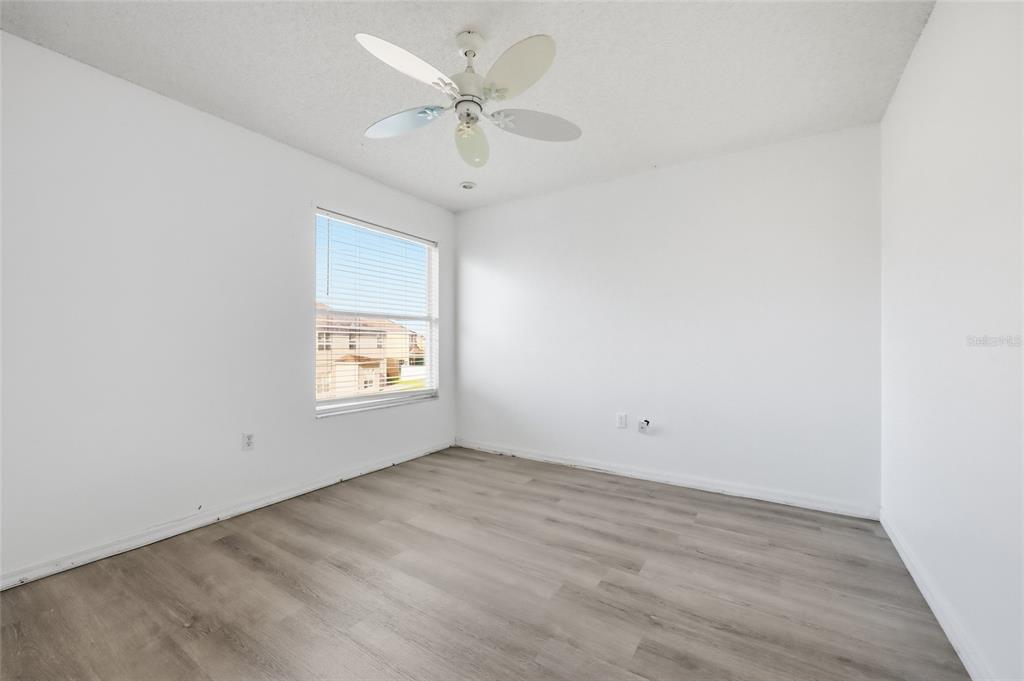 547 Brighton Court Kissimmee, FL 34758 - Photo 18 of 36 an empty room with a window and a ceiling fan