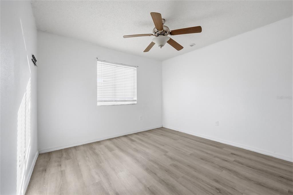 547 Brighton Court Kissimmee, FL 34758 - Photo 20 of 36 an empty room with wooden floor fan and windows