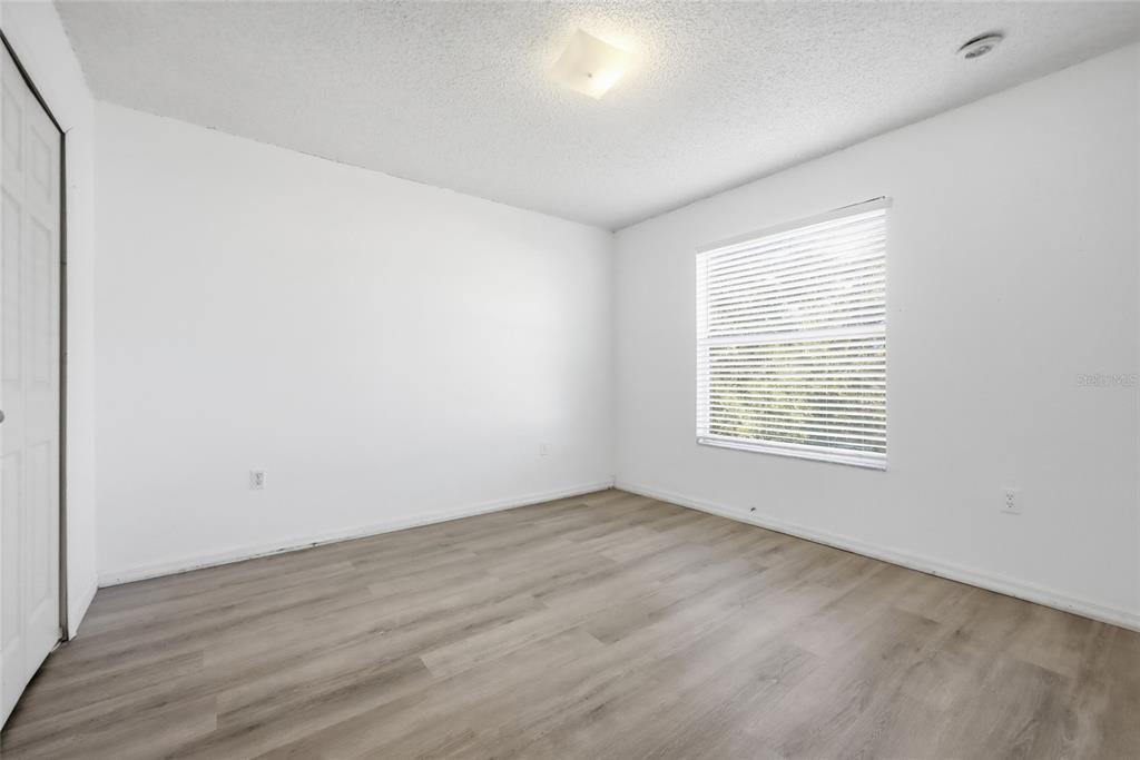 547 Brighton Court Kissimmee, FL 34758 - Photo 22 of 36 an empty room with wooden floor and windows