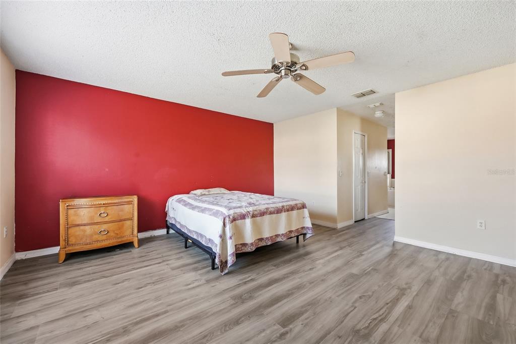 547 Brighton Court Kissimmee, FL 34758 - Photo 26 of 36 a bedroom with a bed and a chandelier