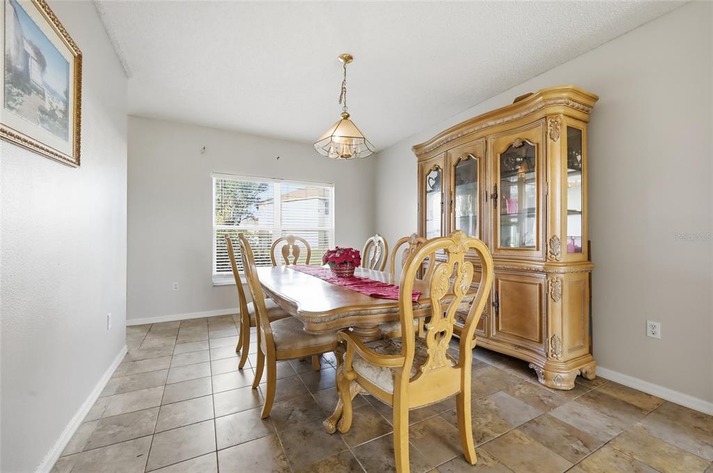 547 Brighton Court Kissimmee, FL 34758 - Photo 8 of 36 a dining room with furniture a chandelier and window