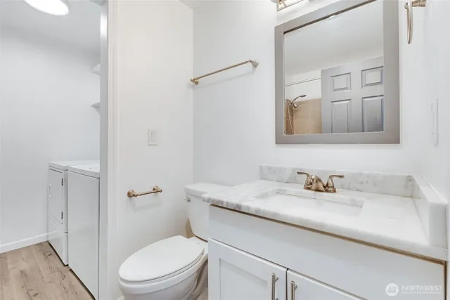 a bathroom with a granite countertop sink toilet and mirror