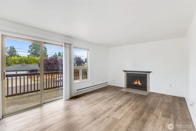 a view of empty room with wooden floor and fireplace