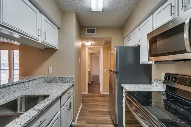 a kitchen with stainless steel appliances granite countertop a sink and cabinets