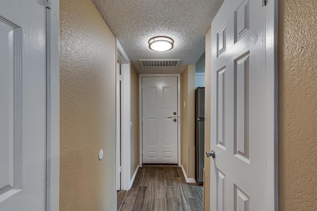 9611 Walnut Street, Unit 1106 Dallas, TX 75081 - Photo 16 of 31 a view of a hallway with wooden floor and a livingroom