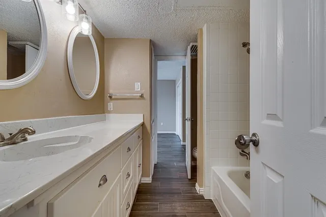a bathroom with a granite countertop double vanity sink and a mirror