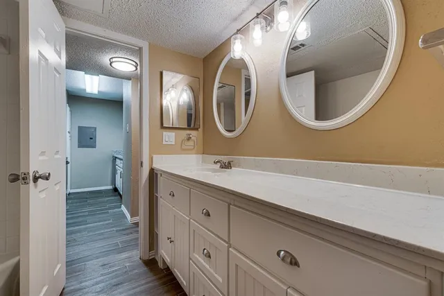 a bathroom with a granite countertop sink mirror and bathtub