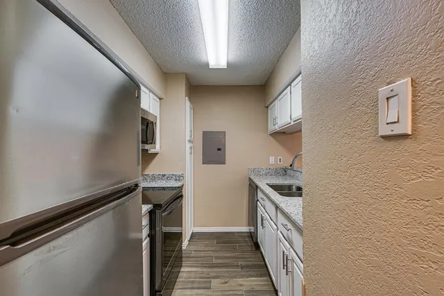 a kitchen with granite countertop white cabinets and a sink