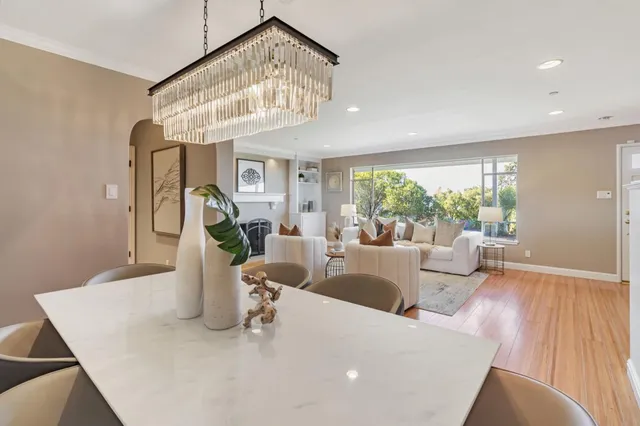 a dining room with furniture a chandelier and wooden floor