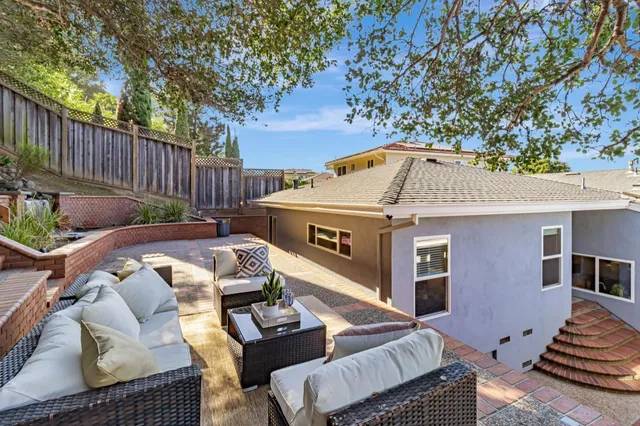 front view of a house with a small yard and potted plants