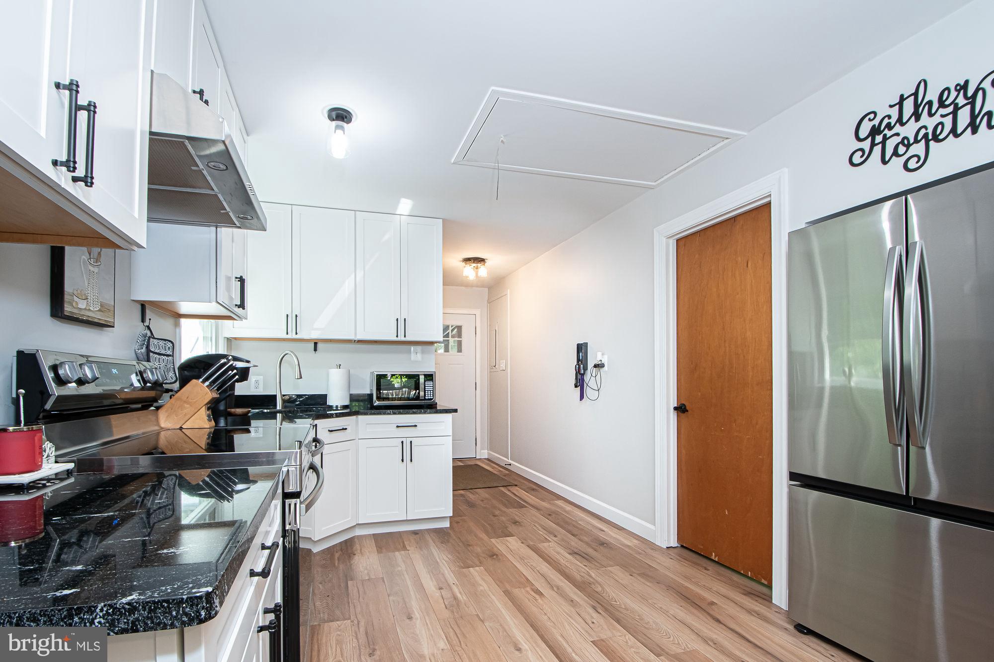 61 Mt Marshall Road Washington, VA 22747 - Photo 12 of 54 a kitchen with stainless steel appliances granite countertop a refrigerator a sink dishwasher a stove and white cabinets with wooden floor