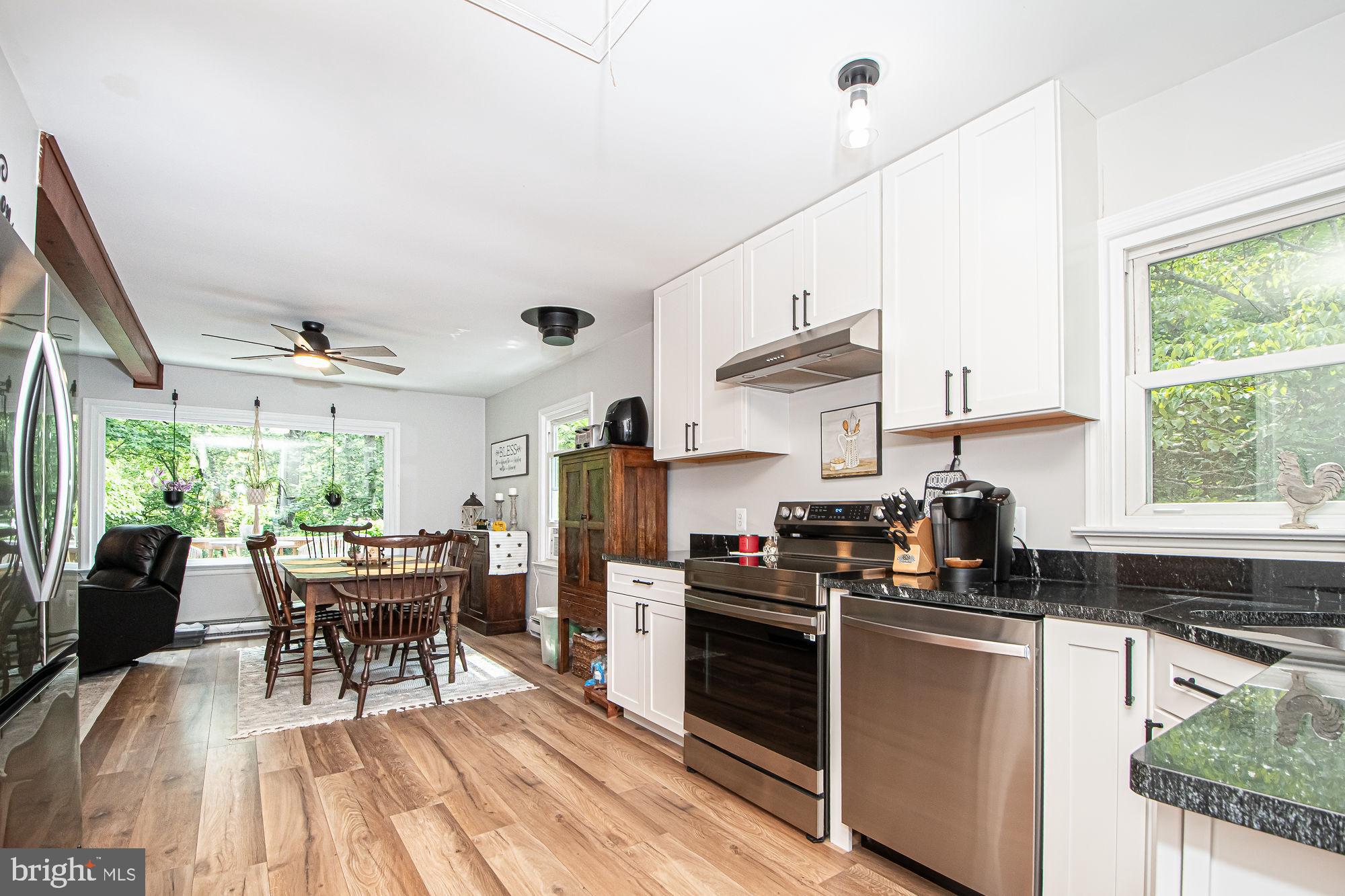 61 Mt Marshall Road Washington, VA 22747 - Photo 13 of 54 a kitchen with stainless steel appliances granite countertop a stove top oven a sink dishwasher a dining table and chairs with wooden floor