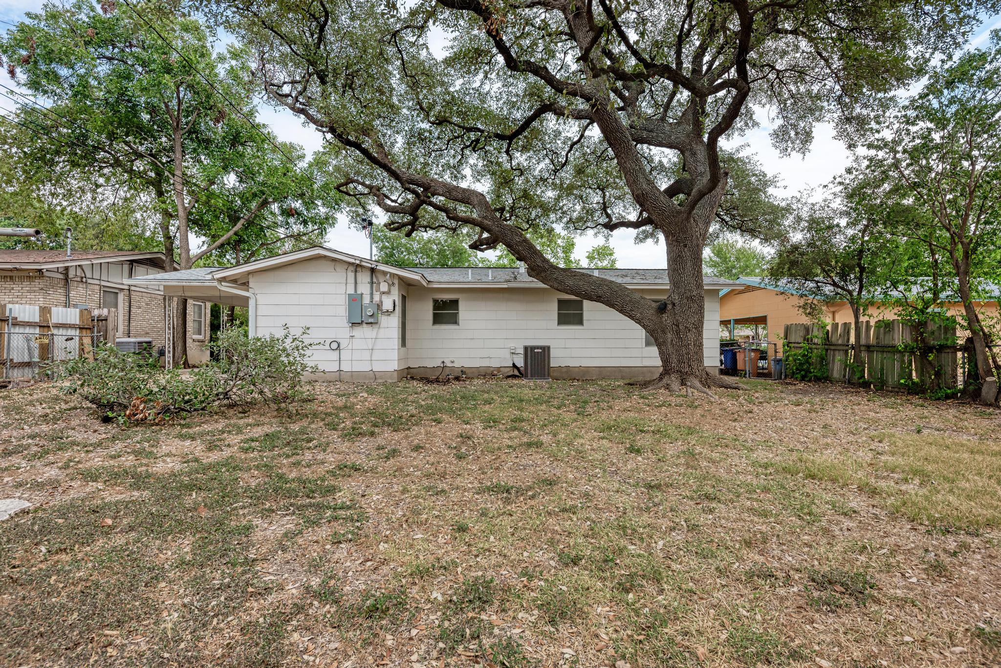 7804 Rutgers Avenue Austin, TX 78757 - Photo 25 of 32 A spacious grassy yard sits beneath the shade of mature, sprawling trees.
