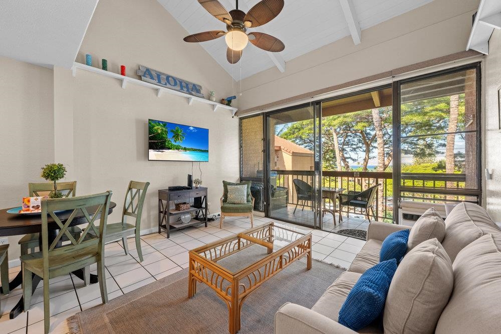 2191 South Kihei Road, Unit 2413 Kihei, HI 96753 - Photo 3 of 32 a living room with furniture a flat screen tv and a floor to ceiling window