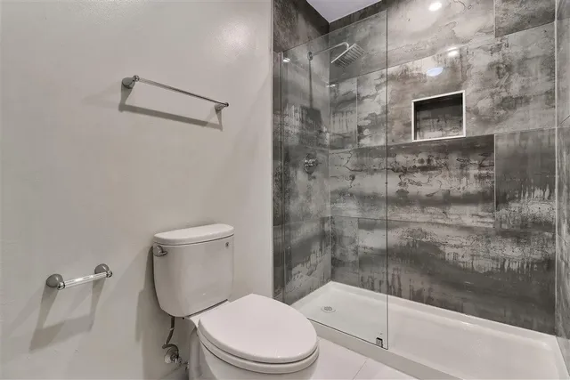 a white toilet next to a bathroom shower