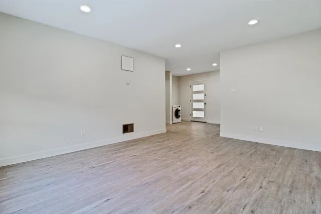 a view of empty room with wooden floor