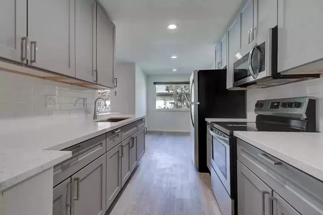 a kitchen with stainless steel appliances granite countertop a stove a sink and a refrigerator