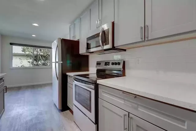 a kitchen with stainless steel appliances a stove microwave and refrigerator