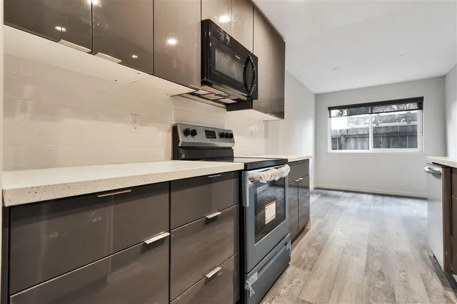 a kitchen with stainless steel appliances a sink a stove top oven a chimney and a center island