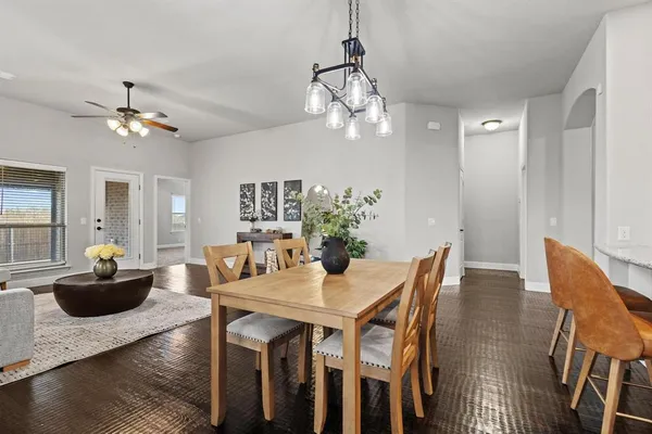 a view of a dining room with furniture a chandelier and wooden floor