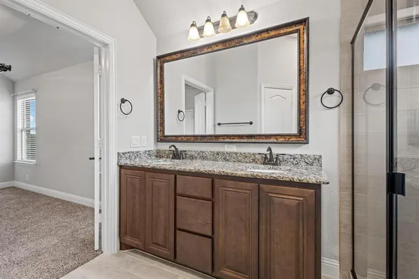 a bathroom with a granite countertop sink vanity and mirror