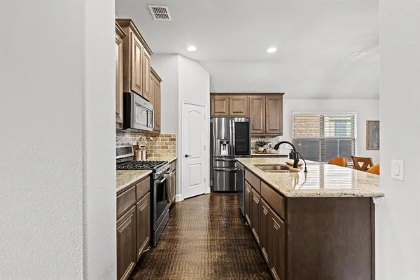 a kitchen with a sink stove top oven and refrigerator