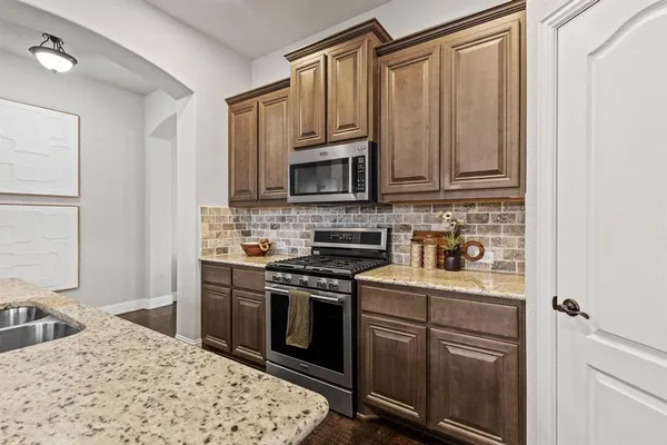 a kitchen with stainless steel appliances granite countertop a stove top oven a sink and dishwasher