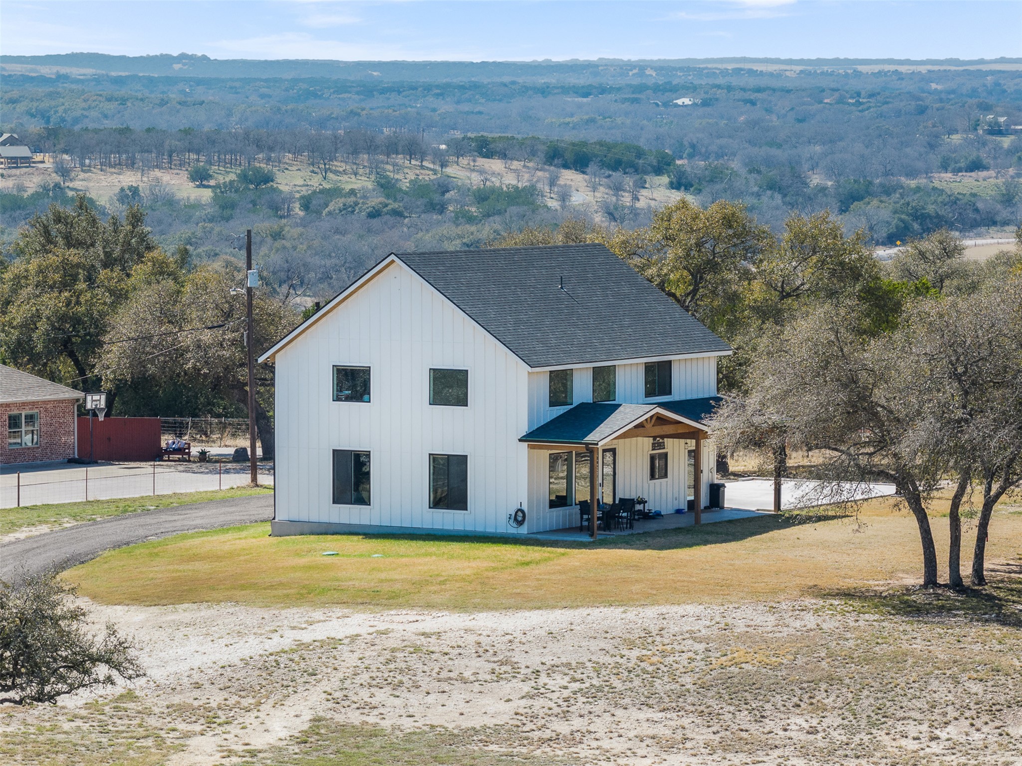 1800 Diamond Ridge Drive Lampasas, TX 76550 - Photo 1 of 40 Modern farmhouse style home featuring a shingled roof, board and batten siding, a view of trees, and a porch