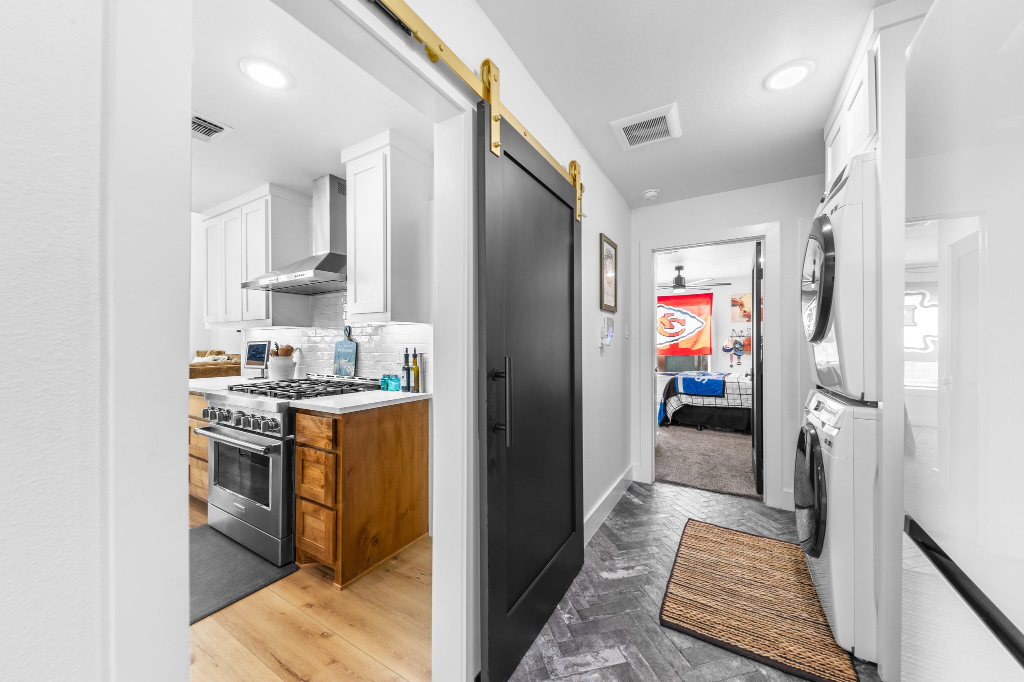 1800 Diamond Ridge Drive Lampasas, TX 76550 - Photo 14 of 40 Kitchen featuring a barn door, parquet flooring, two tone cabinets, stainless steel range, and stacked washer and clothes dryer