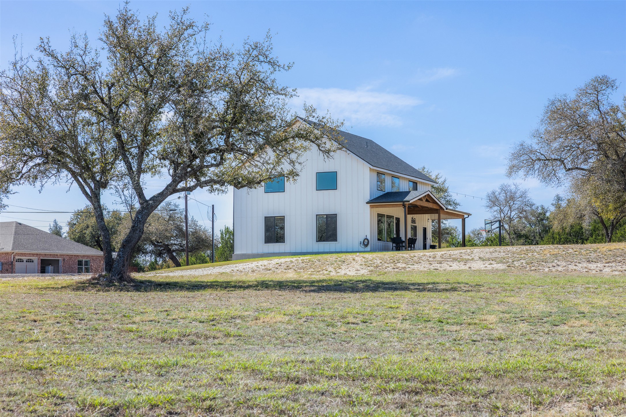 1800 Diamond Ridge Drive Lampasas, TX 76550 - Photo 3 of 40 Rear view of house with a patio, board and batten siding, and a yard