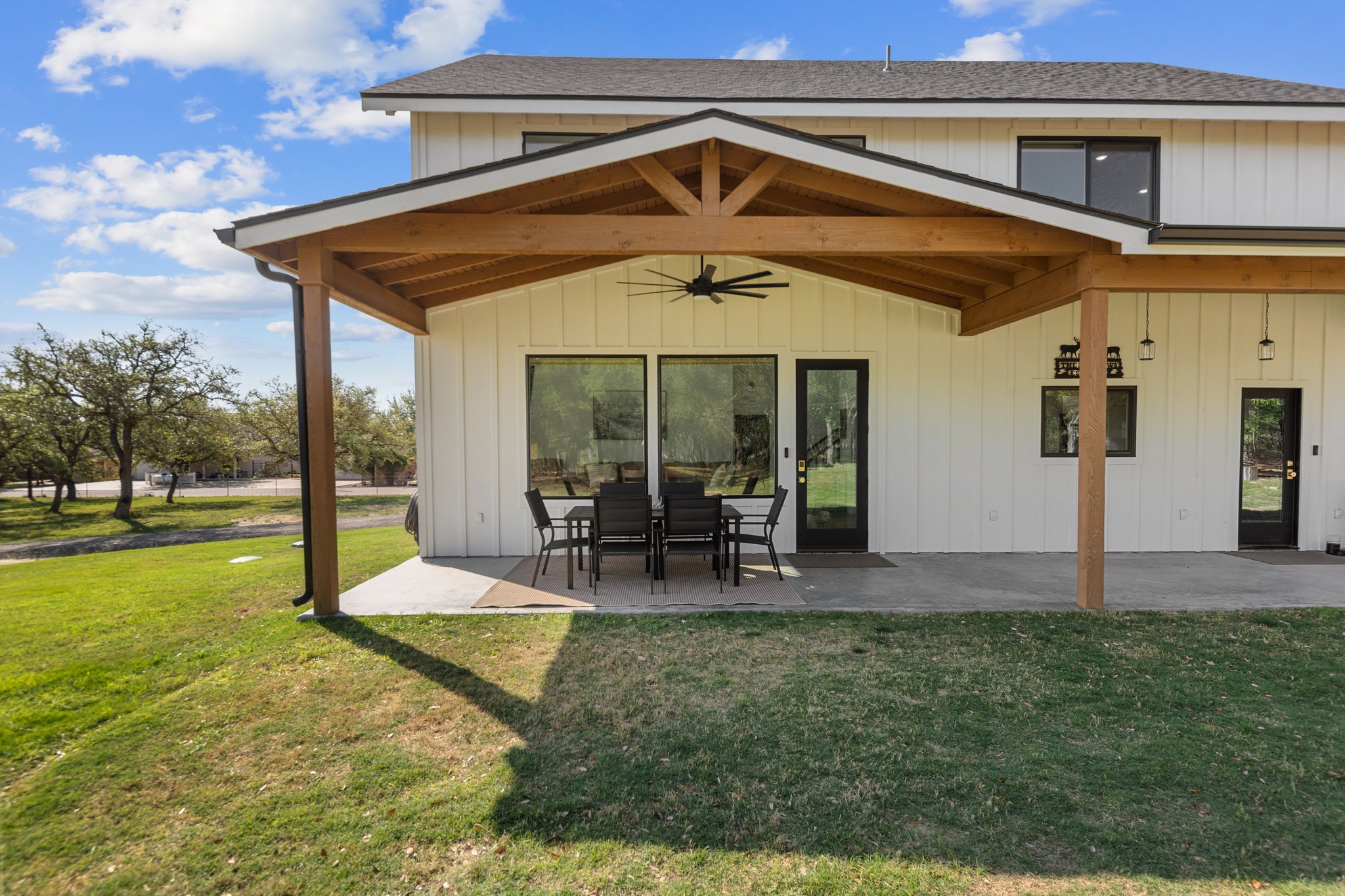 1800 Diamond Ridge Drive Lampasas, TX 76550 - Photo 31 of 40 Rear view of house featuring a ceiling fan, a patio, a lawn, and board and batten siding