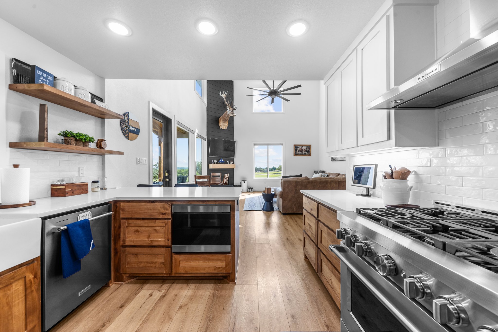1800 Diamond Ridge Drive Lampasas, TX 76550 - Photo 5 of 40 Kitchen featuring backsplash, stainless steel appliances, ceiling fan, a peninsula, and light wood-style flooring