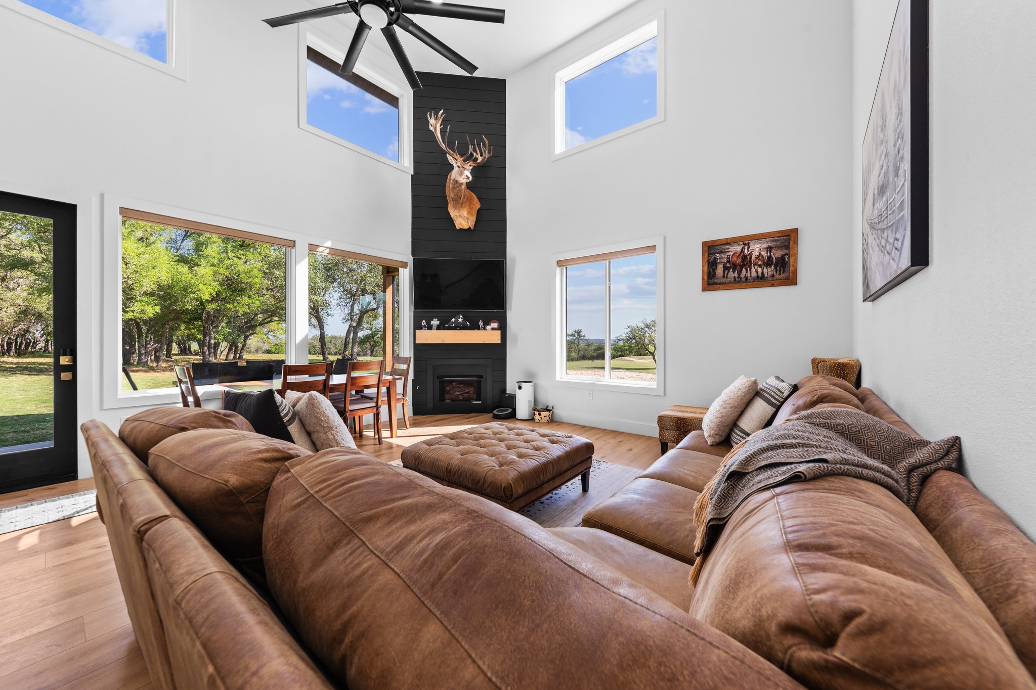 1800 Diamond Ridge Drive Lampasas, TX 76550 - Photo 6 of 40 Living area featuring wood finished floors, a ceiling fan, a high ceiling, and a fireplace