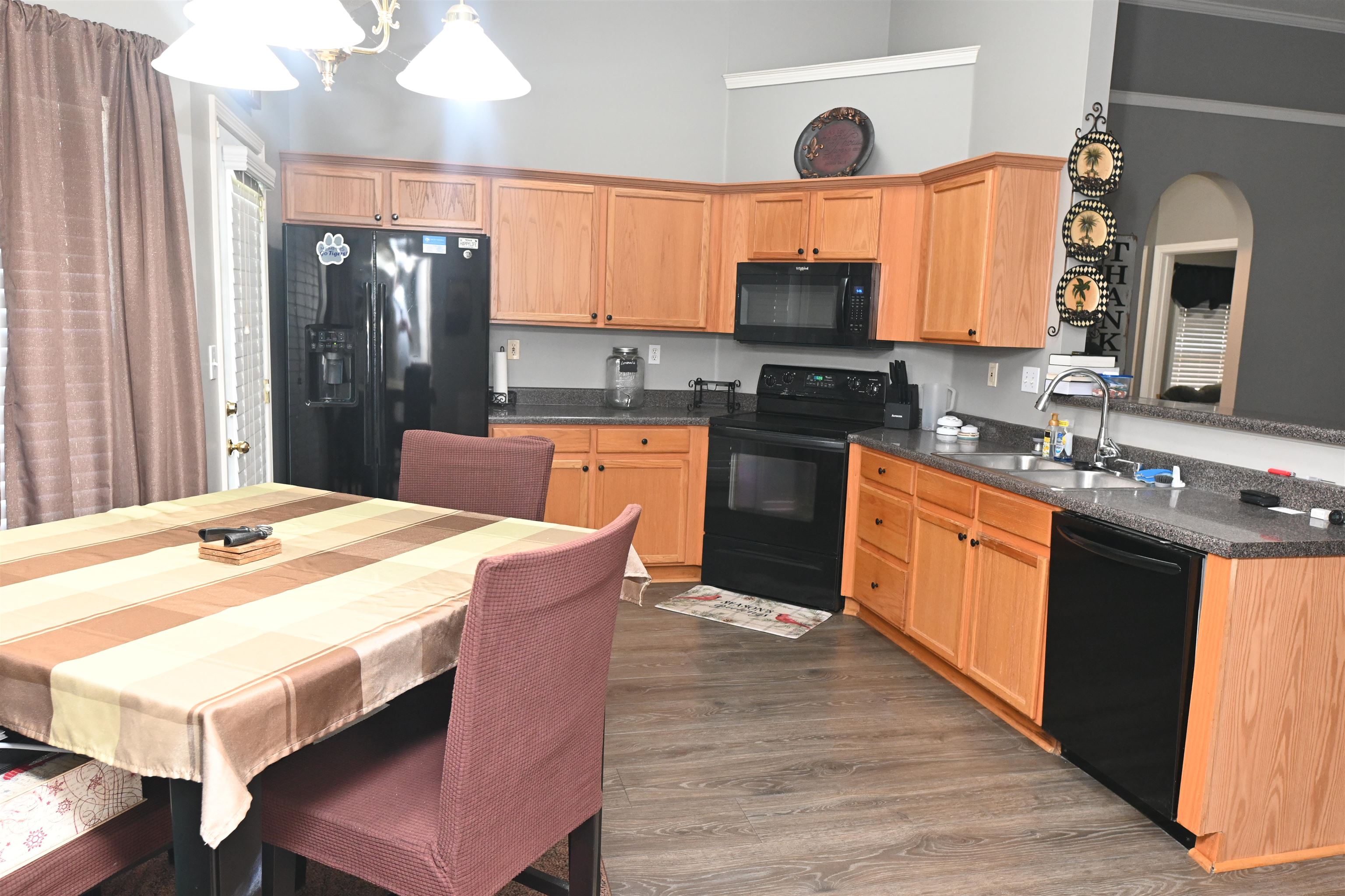 2736 Java Drive Memphis, TN 38002 - Photo 8 of 21 Kitchen featuring black appliances, dark wood-style flooring, dark countertops, light brown cabinets, and a towering ceiling