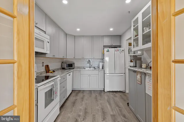 a kitchen with a refrigerator a stove top oven and cabinets