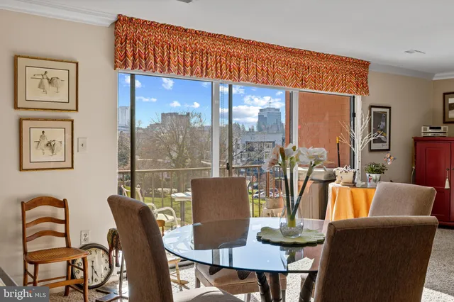 a dining room with furniture a large window and a glass door