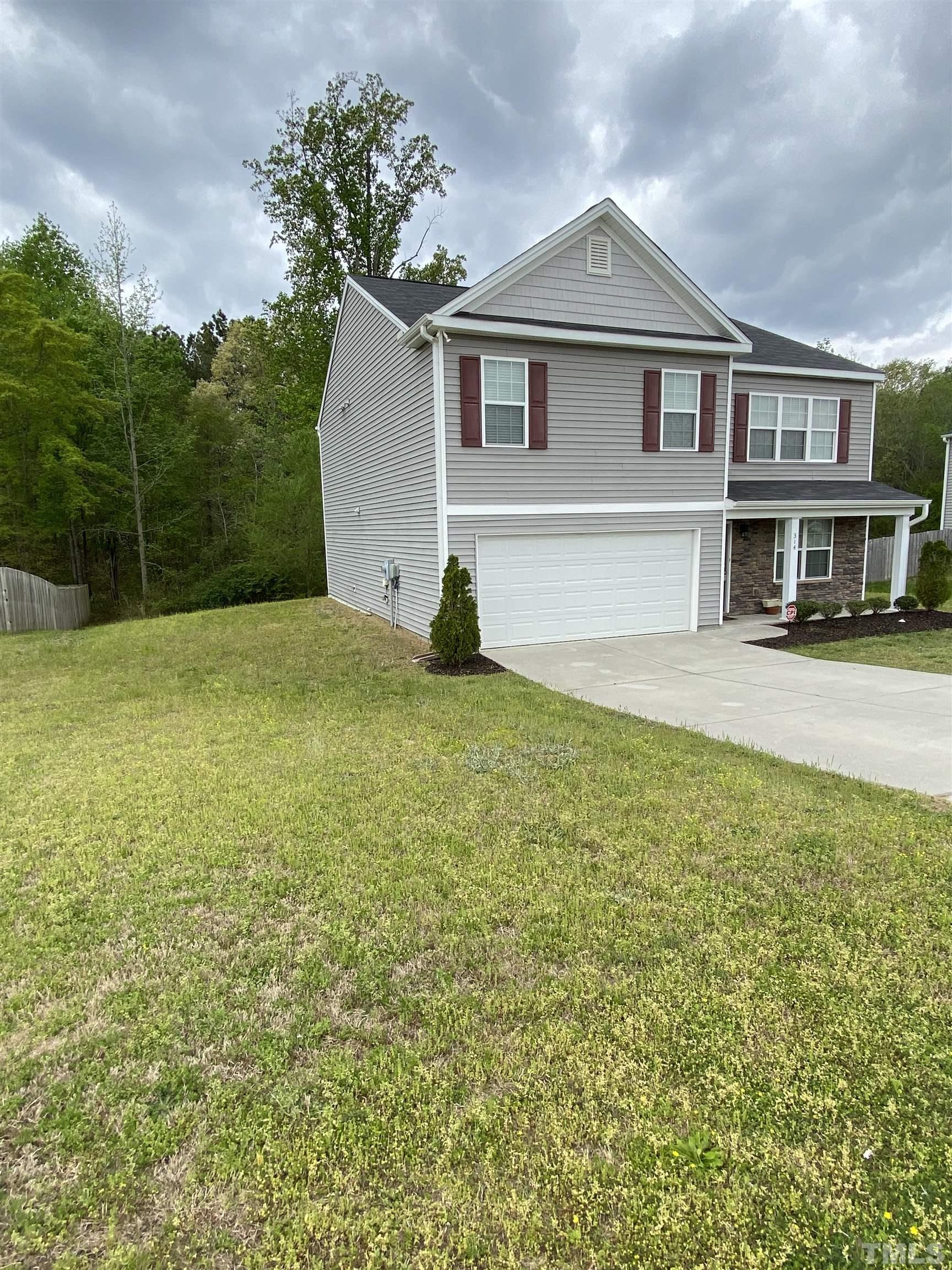 314 Botanical Court Bunnlevel, NC 28323 - Photo 2 of 8 a view of a house with a yard and garage