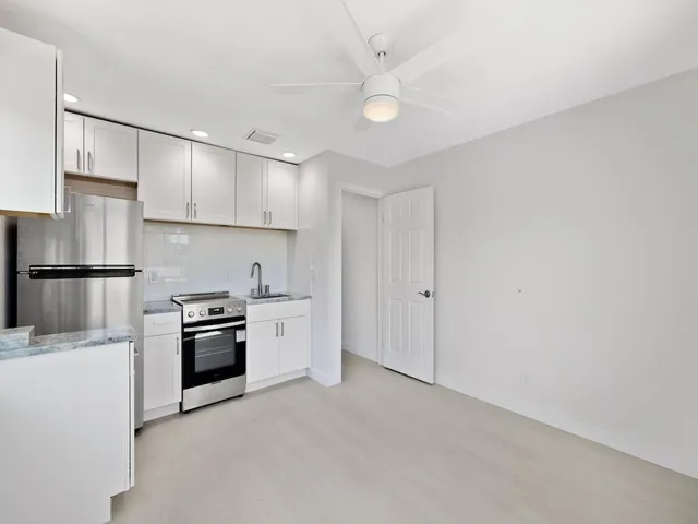 a kitchen with stainless steel appliances granite countertop a stove and a white cabinets