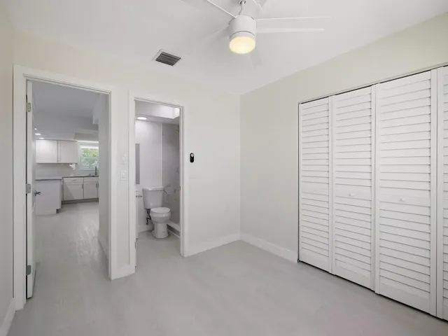 an empty room with windows and ceiling fan