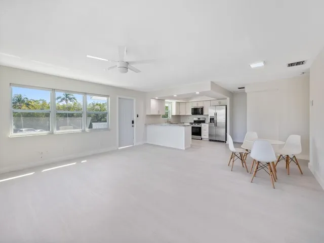 a kitchen with white cabinets stainless steel appliances and a window